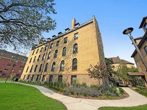 A large brick building with a clock tower on the top floor.