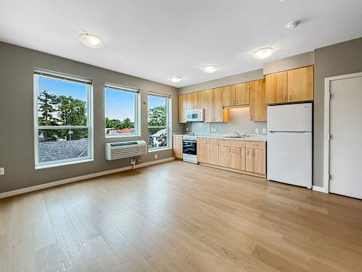 A kitchen with wooden floors and white appliances.