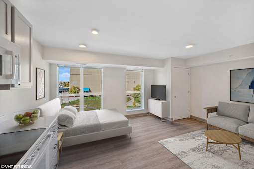 A modern living room with a large bed, a couch, and a television.
