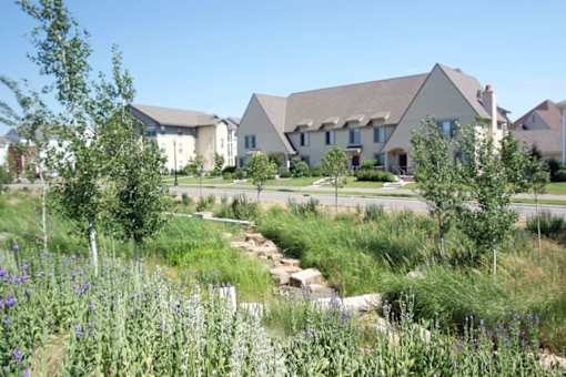 A row of houses with a green field in front.