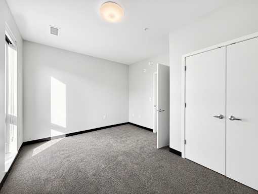 A room with a carpeted floor and white walls.