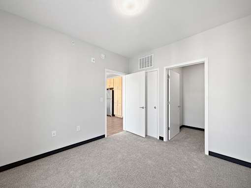 A white room with a carpeted floor and two doors.