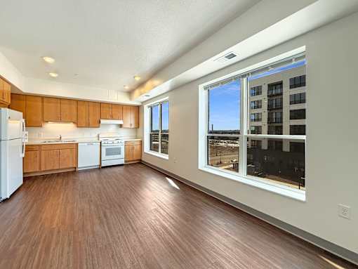A kitchen with wooden floors and white appliances at The Lumin in the Highland Park neighborhood of St Paul