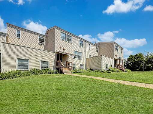 A row of houses with a green lawn in front.
