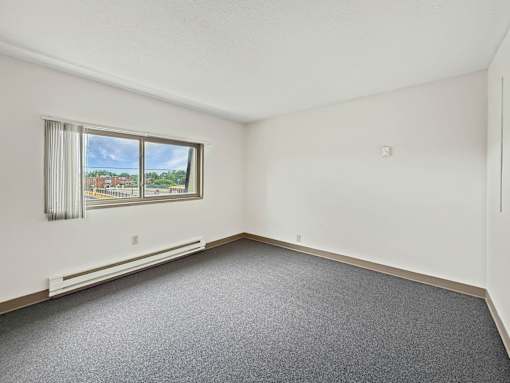 A photo of a Liberty Plaza Townhome bedroom with window and carpeted floor