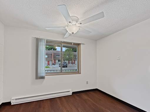 A photo of a dining area at Liberty Plaza Townhomes with luxury vinyl plank, a ceiling fan and a window.