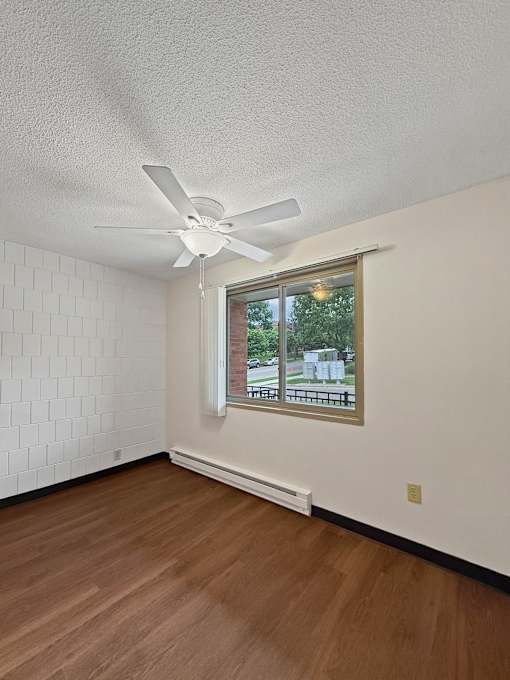 A photo of a dining area at Liberty Plaza Townhomes with luxury vinyl plank, a ceiling fan and a window.