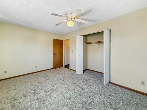 A room with a ceiling fan and a carpeted floor.