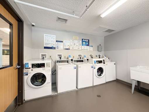 A laundry room with a row of washing machines