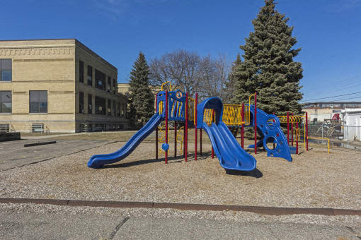 A playground with a blue slide and a yellow structure.
