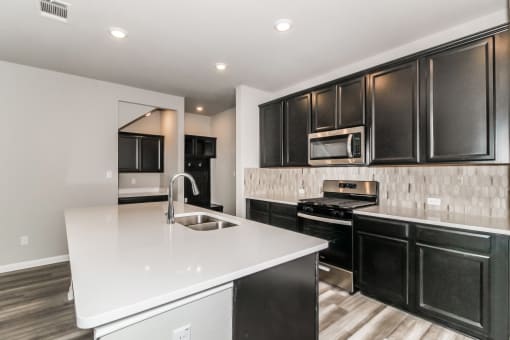 a kitchen with white countertops and black cabinets