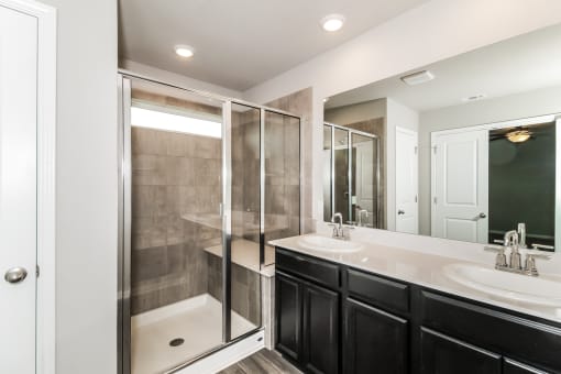a bathroom with a large mirror and a walk in shower