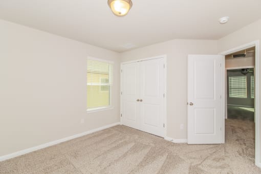 a bedroom with two closets and a carpeted floor