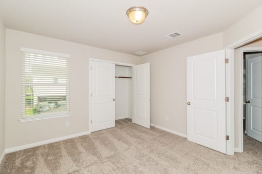 a bedroom with two doors and a closet