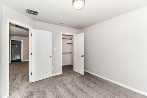 a bedroom with two closets and a carpeted floor