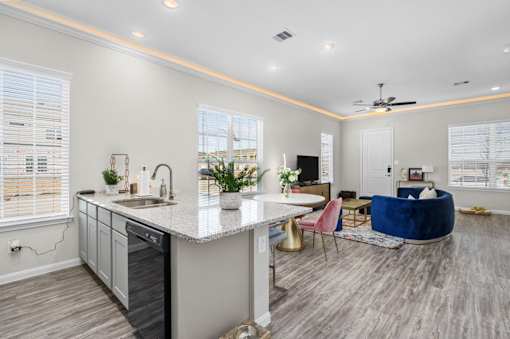 A modern kitchen with a dining area and a living room.