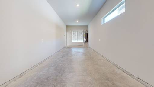 A long, empty hallway with a door at the end.