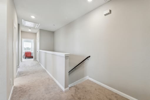 an empty basement with a stairway and white walls and carpet