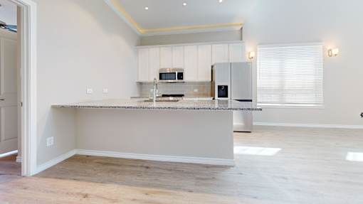 A kitchen with a granite countertop and stainless steel appliances.