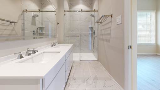 A white bathroom with a walk in shower.