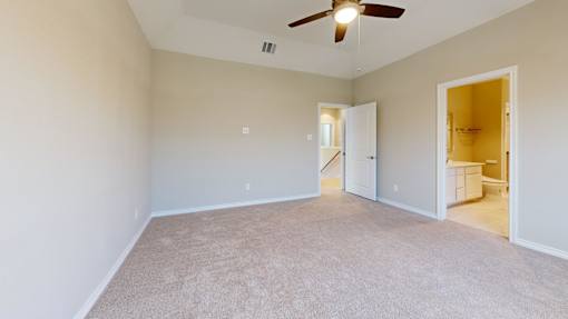 A room with a ceiling fan and carpeted floor.