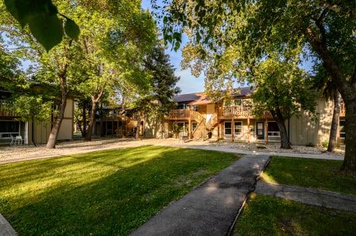 a house with a yard and trees in front of it