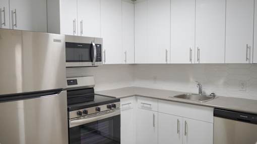 A modern kitchen with stainless steel appliances and white cabinets.