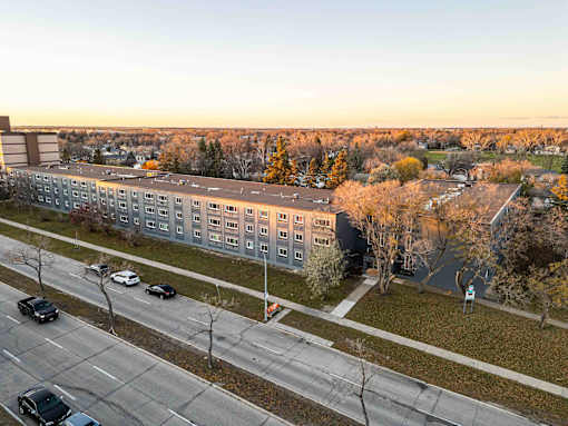 A road with cars and a building in the background.