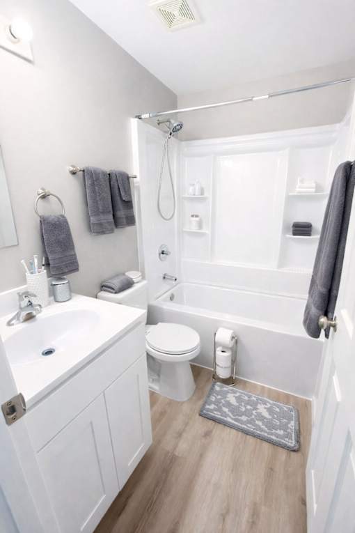 A white bathroom with a toilet, sink, and shower.