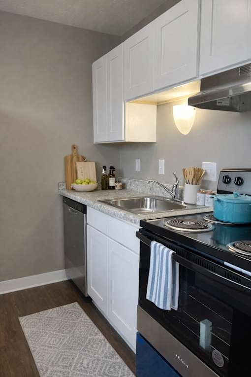 A kitchen with a black stove top oven and white cabinets.