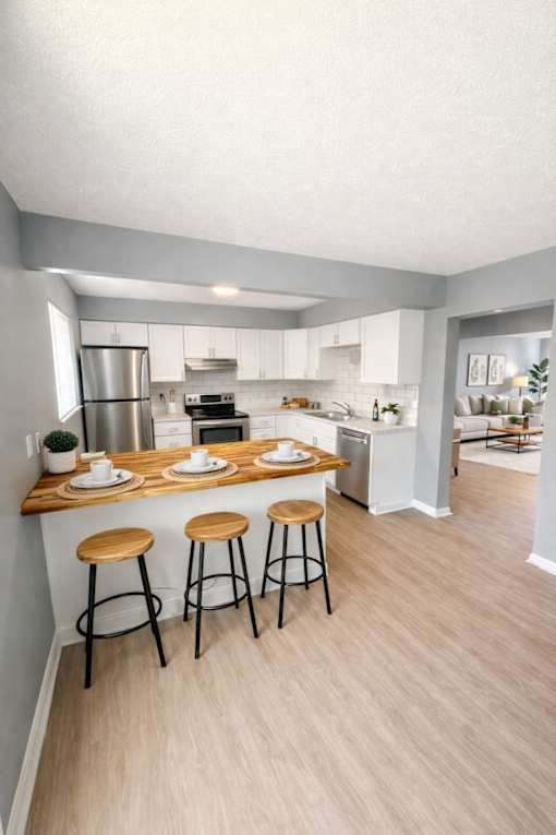 A kitchen with a bar stool and a counter with plates on it.