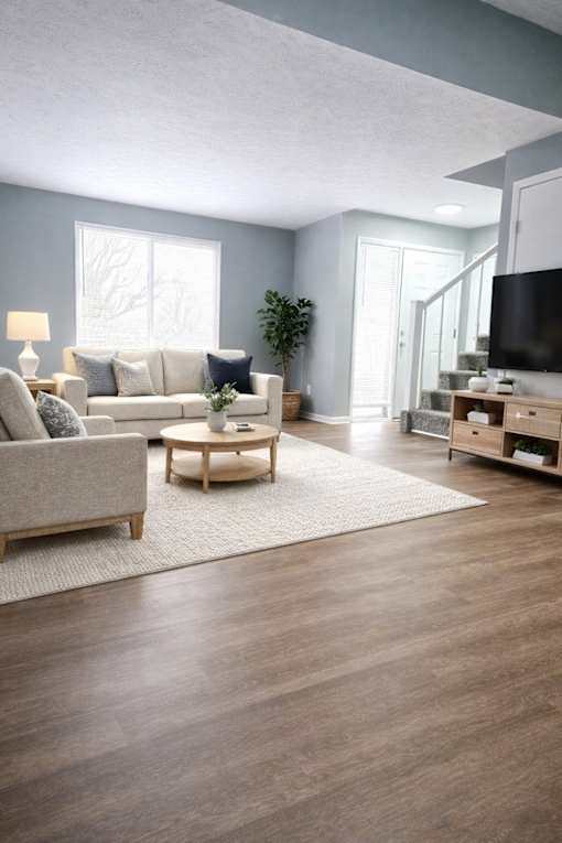 A living room with a grey couch, a coffee table, and a television.