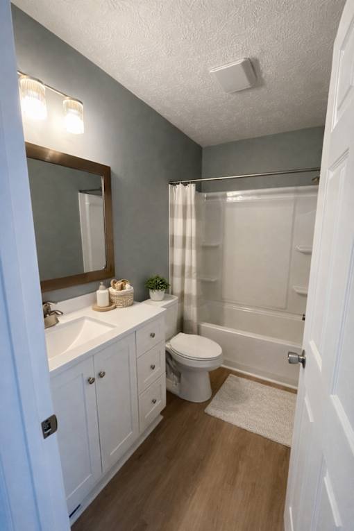 A bathroom with a white toilet, sink, and a mirror.