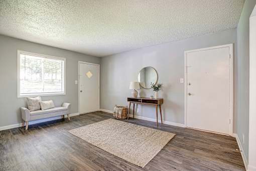 A room with a couch, a table, and a mirror.