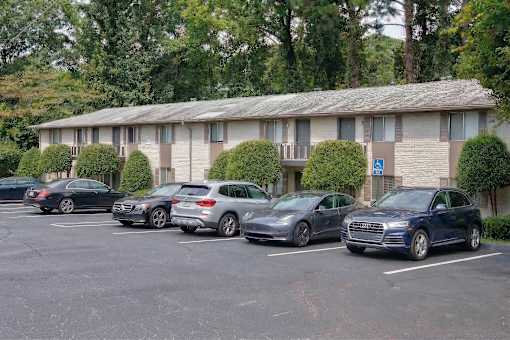 A parking lot with cars and a building in the background.