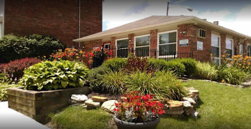 A well-maintained garden in front of a brick building.
