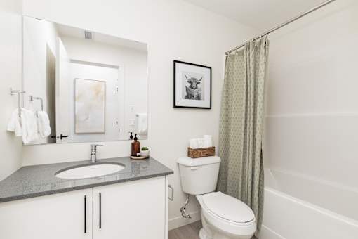 A bathroom with a toilet, sink, and shower.