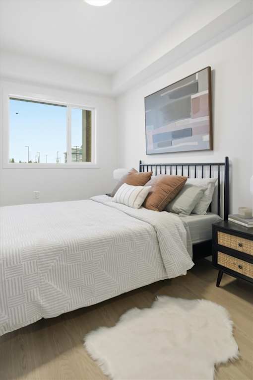 A bedroom with a large bed and a painting on the wall.