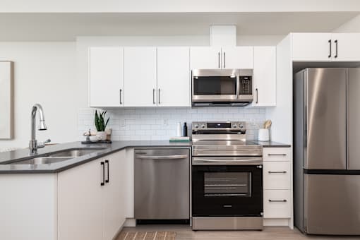 A modern kitchen with stainless steel appliances and white cabinets.