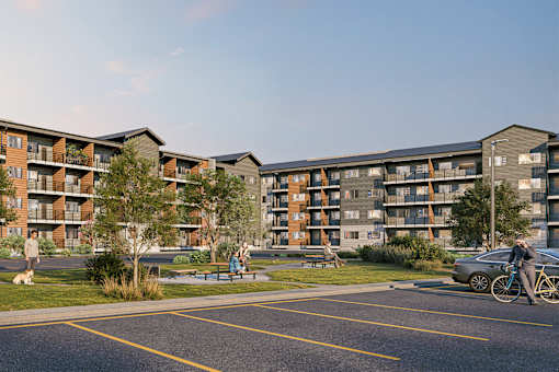 A modern apartment complex with a parking lot in front.