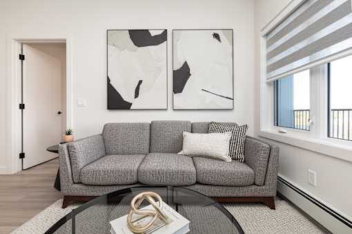 A grey couch with a coffee table in front of it.