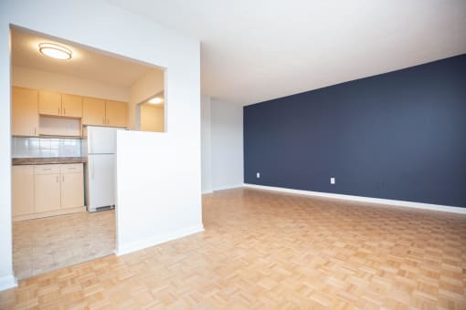 an empty living room and kitchen with a wood floor