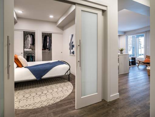 A bedroom with a bed, a wardrobe and a chair.