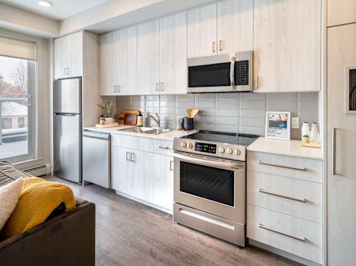 A modern kitchen with stainless steel appliances and wooden cabinets.