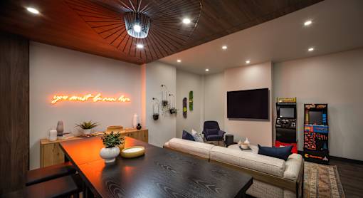 A modern living room with a wooden ceiling and a neon sign that says "your best friend".