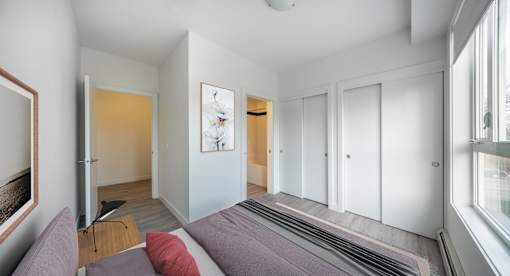 A bedroom with a bed and a painting on the wall.