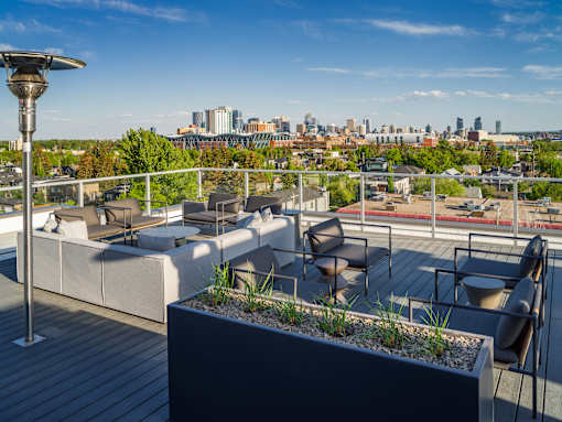 A rooftop patio with a view of the city skyline.