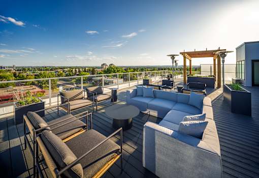 A rooftop patio with a table and chairs.