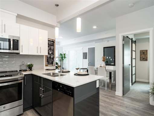 A modern kitchen with a large island and stainless steel appliances.