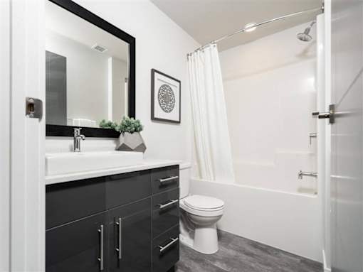 A bathroom with a white toilet and a black and white theme.